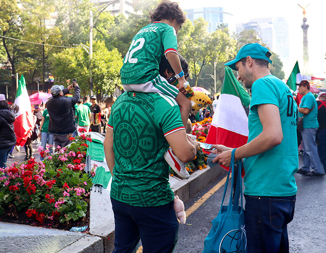 En frivillig fra Stoffri Verden uddeler hæfter til fans nær Uafhængighedsengel-monumentet i Mexico City (til venstre). Colombianske fans får overrakt hæfter i Los Angeles – en af de 16 værtsbyer under VM hvor Stoffri Verdens hold fik spredt budskabet.